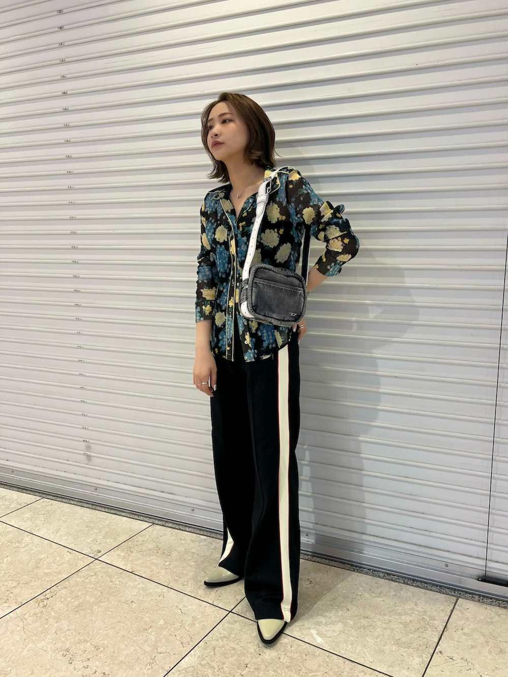 ブラック系のハンドバッグ、ブラック系のシャツ/ブラウス、ブラック系のその他パンツを着用したレディースの春コーディネートの2枚目の写真