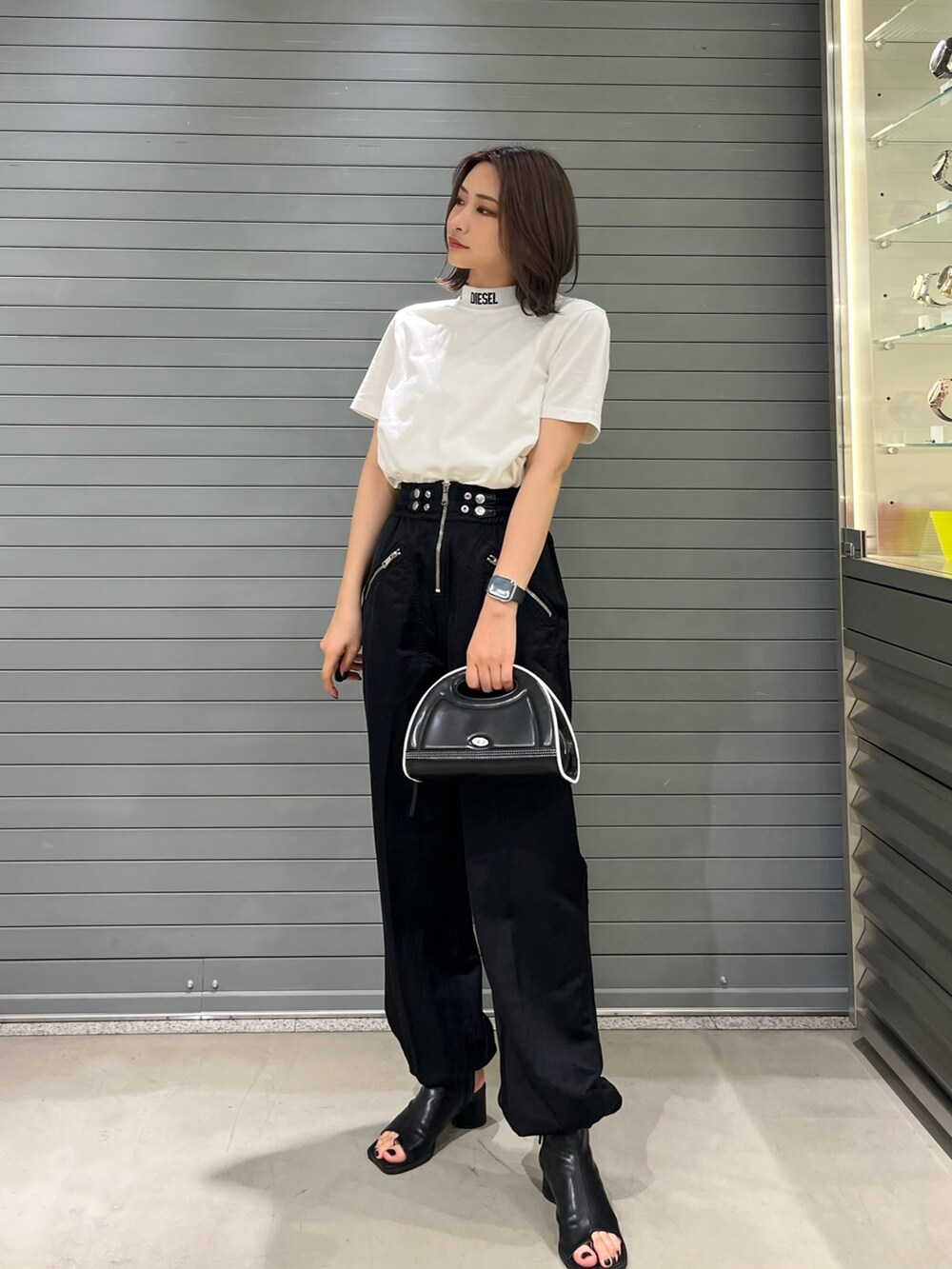 ホワイト系のTシャツ/カットソー、ブラック系のカーゴパンツ、ブラック系のハンドバッグを着用したレディースの秋コーディネートの2枚目の写真