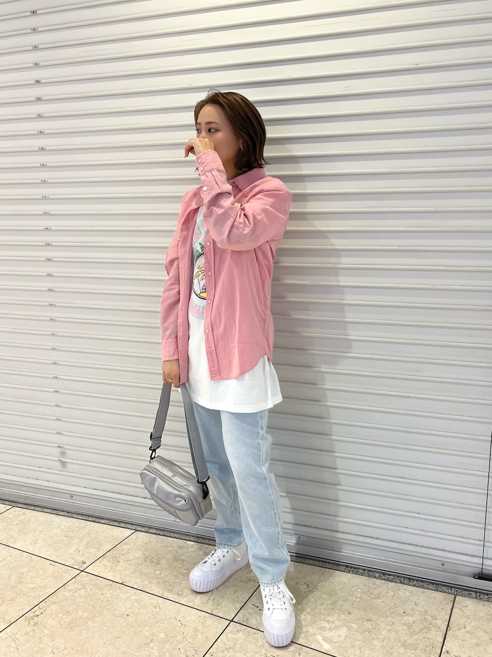 ピンク系のシャツ/ブラウス、ホワイト系のTシャツ/カットソー、グレー系のショルダーバッグを着用したレディースの春コーディネートの2枚目の写真