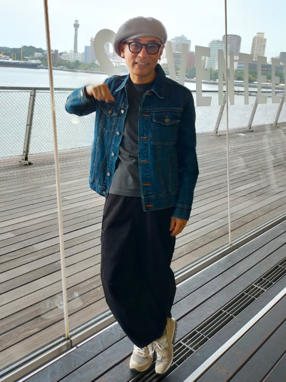 グレー系のスニーカー、ブラック系のカーゴパンツ、グリーン系のTシャツ/カットソーを着用したメンズの春コーディネートの3枚目の写真