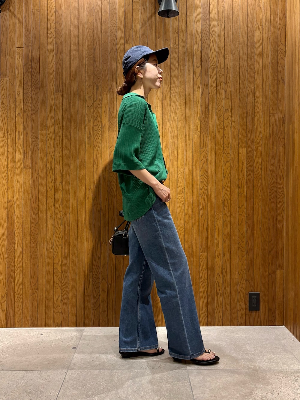 ホワイト系のTシャツ/カットソー、ブルー系のデニムパンツ、ブラック系のハンドバッグを着用したレディースの夏コーディネートの6枚目の写真