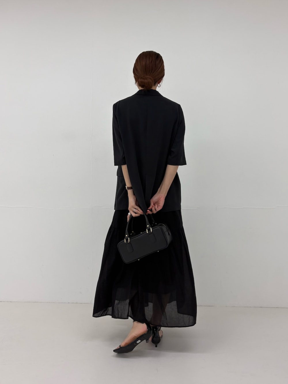 ブラック系のその他アウター、ブラック系のハンドバッグ、ブラック系のワンピースを着用したレディースの春コーディネートの4枚目の写真