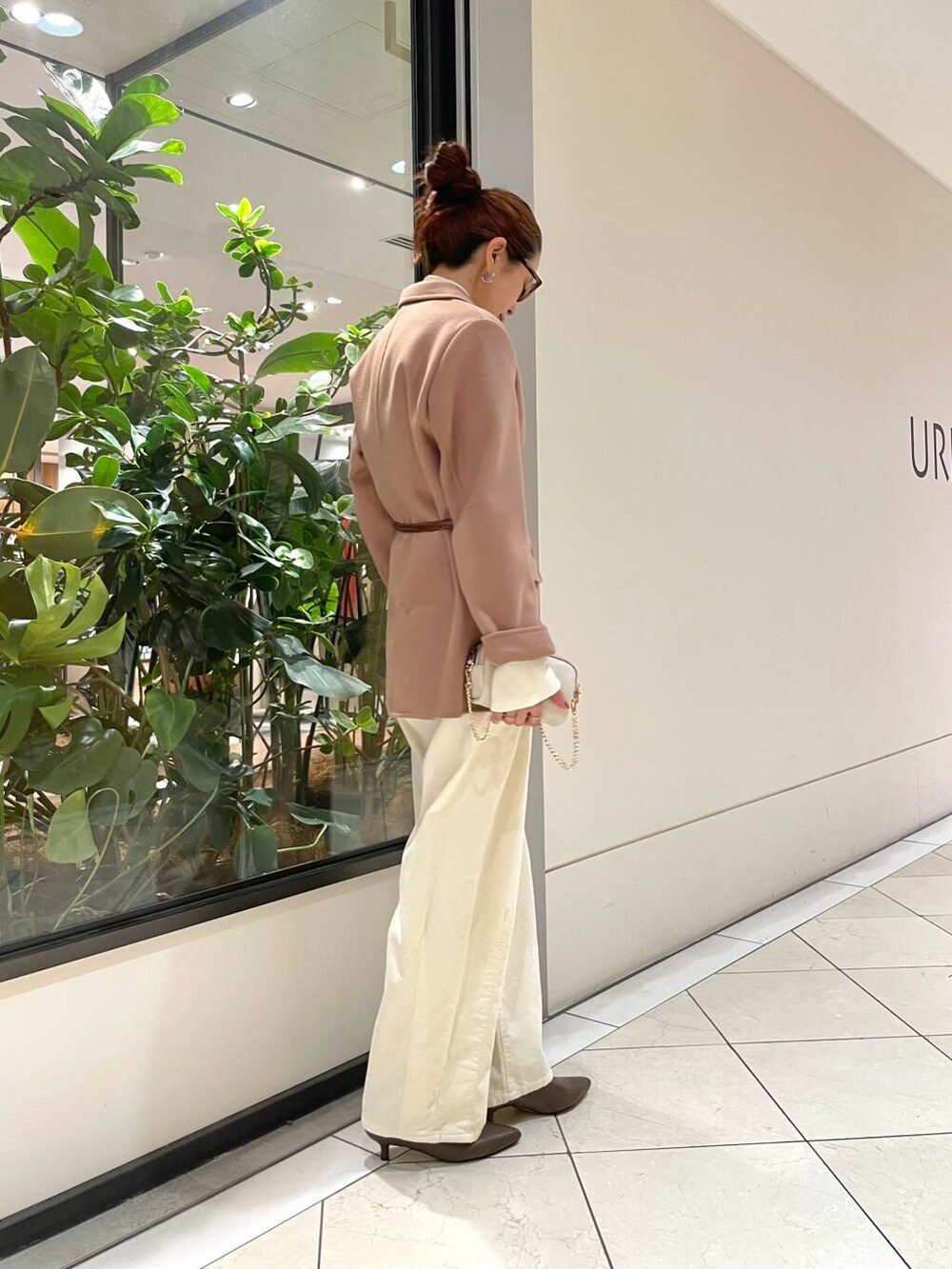 ホワイト系のニット/セーター、ベージュ系のその他アウター、ブラウン系のブーツを着用したレディースの秋コーディネートの2枚目の写真