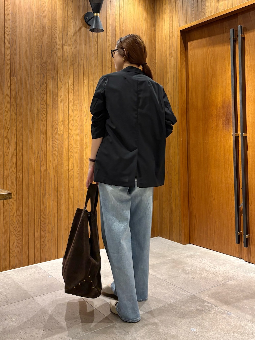 ブルー系のデニムパンツ、ホワイト系のTシャツ/カットソー、ブラック系のテーラードジャケットを着用したレディースの夏コーディネートの3枚目の写真