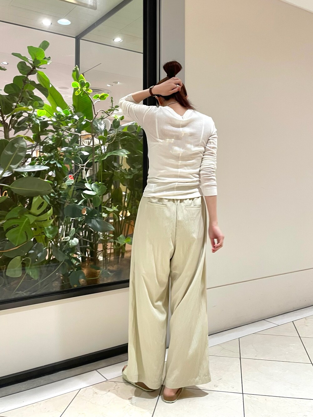 ホワイト系のトップス、ベージュ系のその他パンツ、グリーン系のサンダルを着用したレディースの夏コーディネートの4枚目の写真