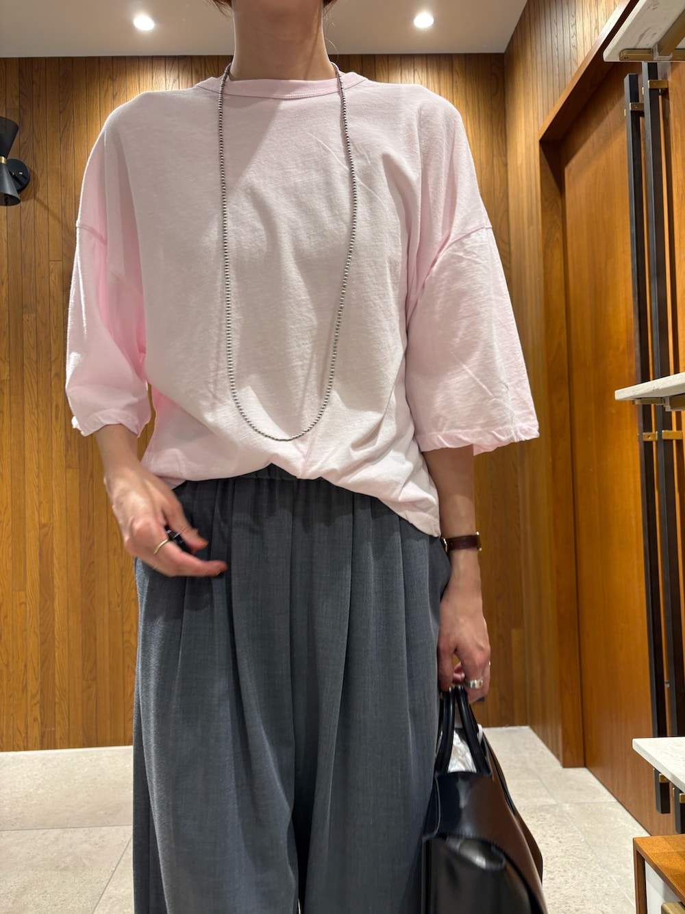 ピンク系のTシャツ/カットソー、グレー系のその他パンツ、ブラック系のスニーカーを着用したレディースの春コーディネートの6枚目の写真