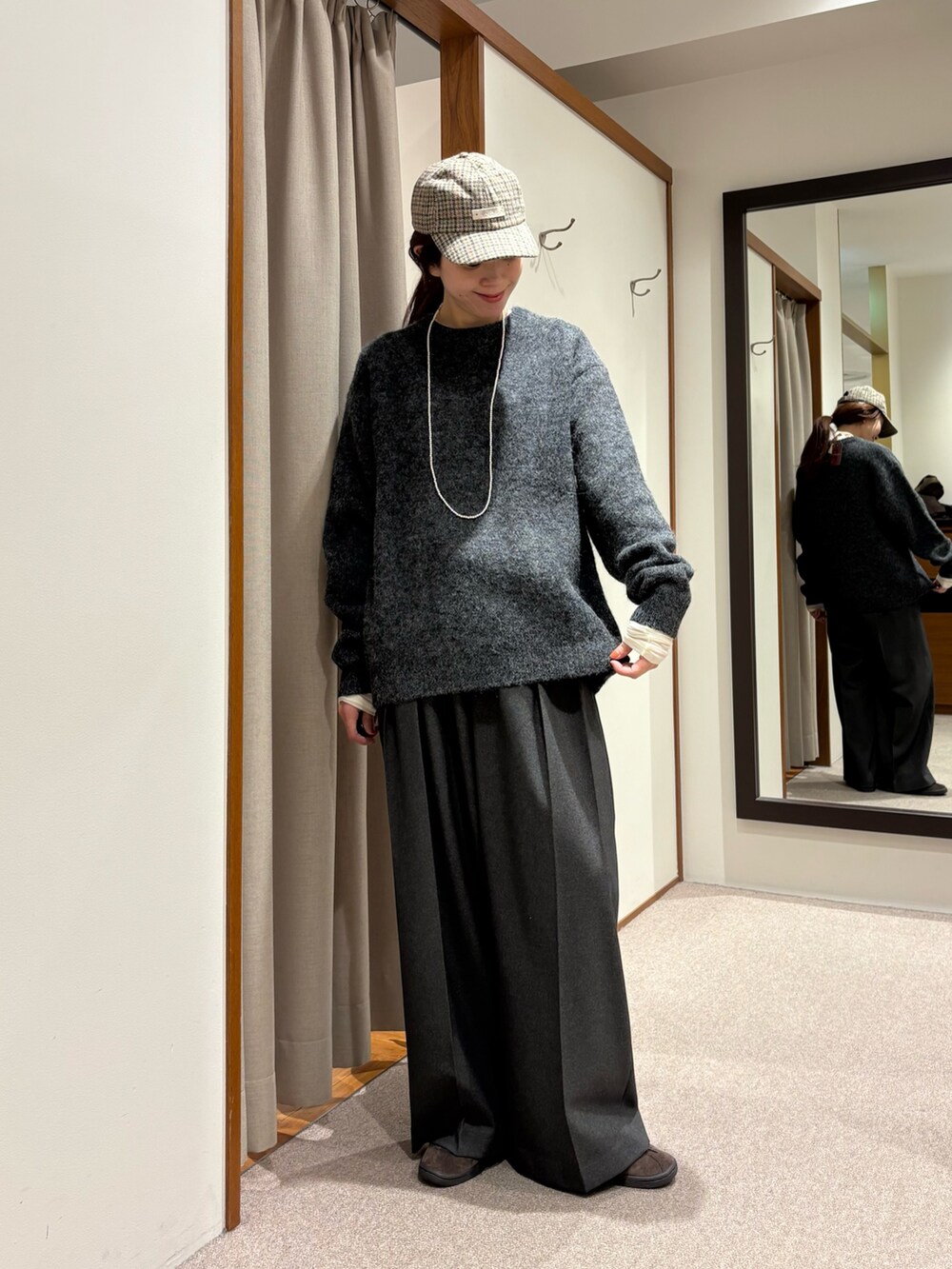 ブラック系のチェスターコート、グレー系のその他パンツ、ブラック系のハンドバッグを着用したレディースの冬コーディネートの5枚目の写真