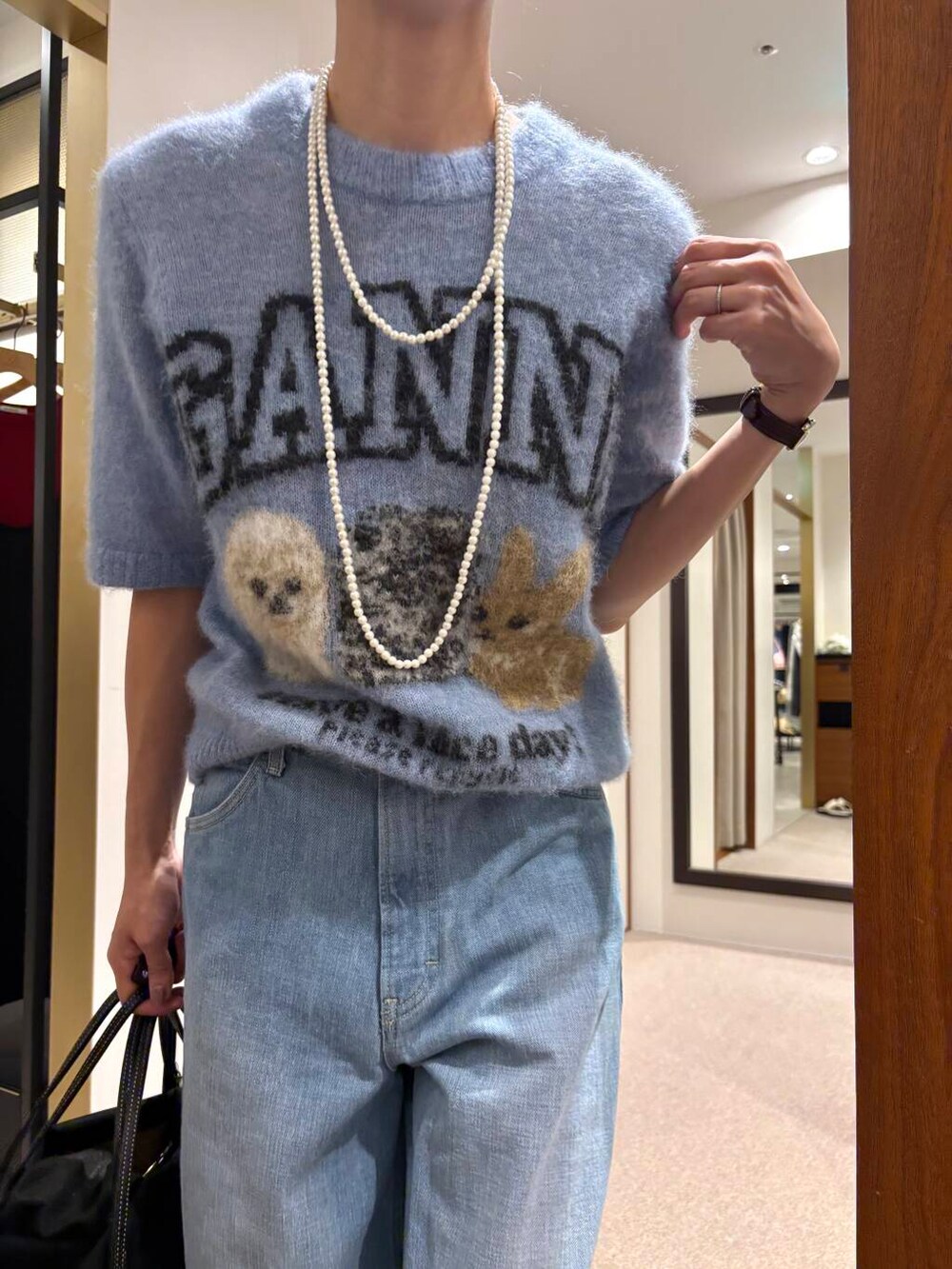 ブルー系のデニムパンツ、ブラック系のサンダルを着用したレディースの夏コーディネートの6枚目の写真