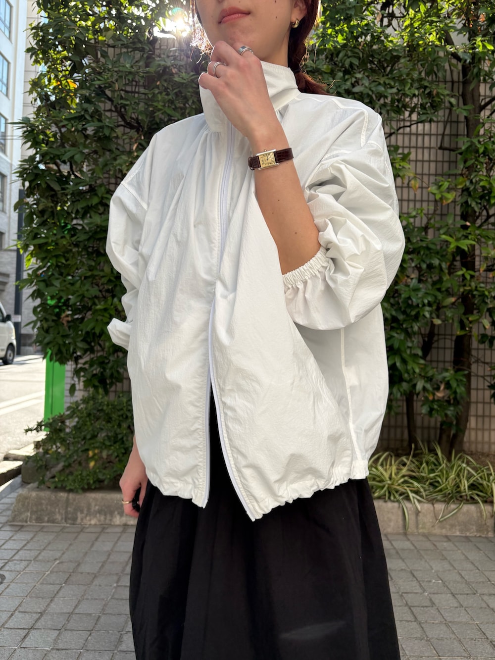 ホワイト系のブルゾン、ブラック系のワンピース、ブラック系のボディバッグ/ウエストポーチを着用したレディースの春コーディネートの4枚目の写真