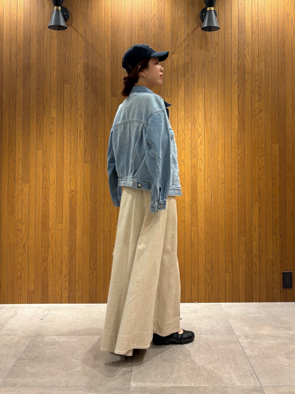 ホワイト系のトートバッグ、ブラック系のTシャツ/カットソー、ブルー系のデニムジャケットを着用したレディースの春コーディネートの4枚目の写真