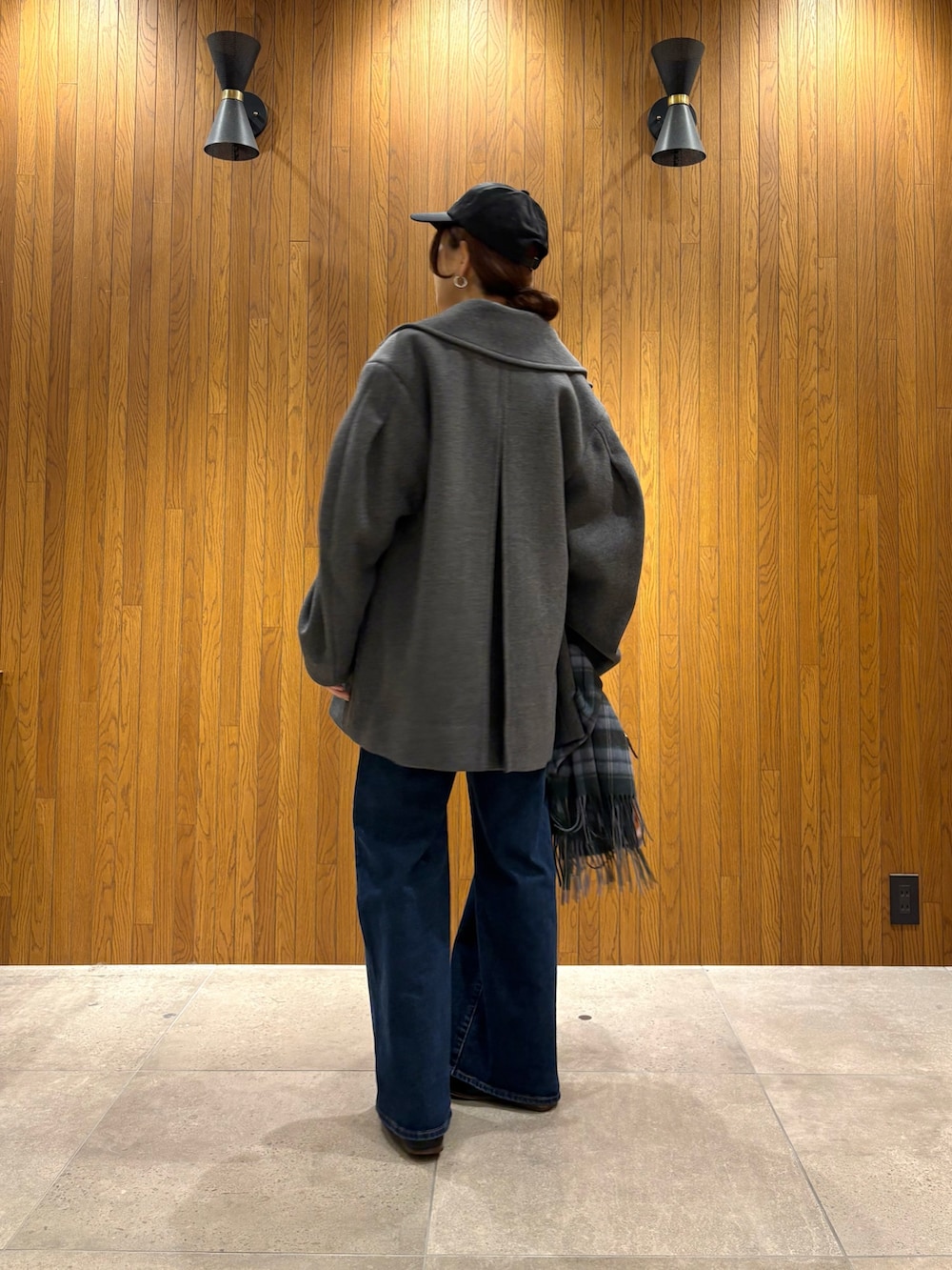 グレー系のその他アウター、イエロー系のニット/セーター、ブルー系のデニムパンツを着用したレディースの冬コーディネートの3枚目の写真