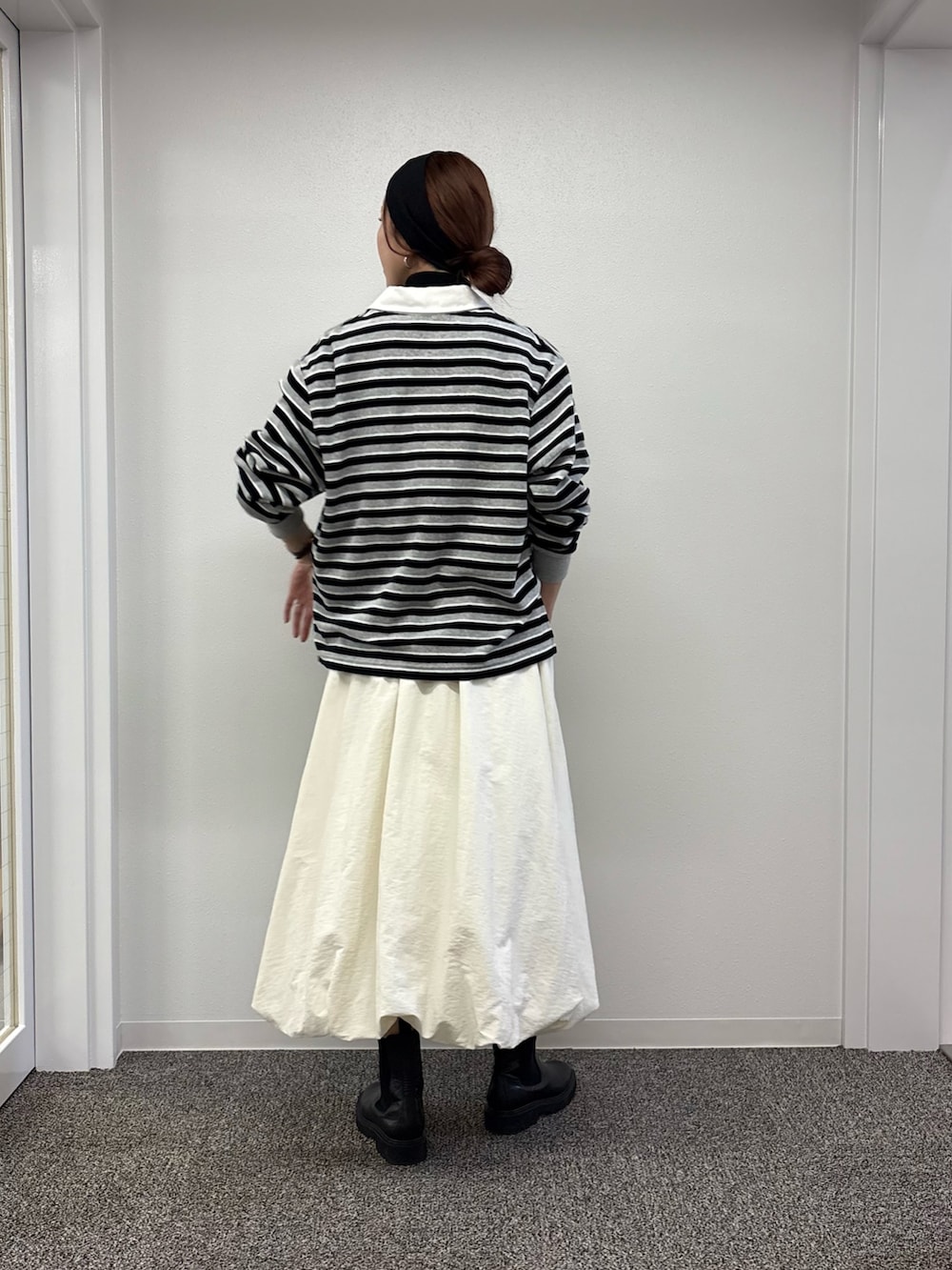 ホワイト系のスカート、ブラック系のニット/セーター、レッド系のTシャツ/カットソーを着用したレディースの秋コーディネートの3枚目の写真