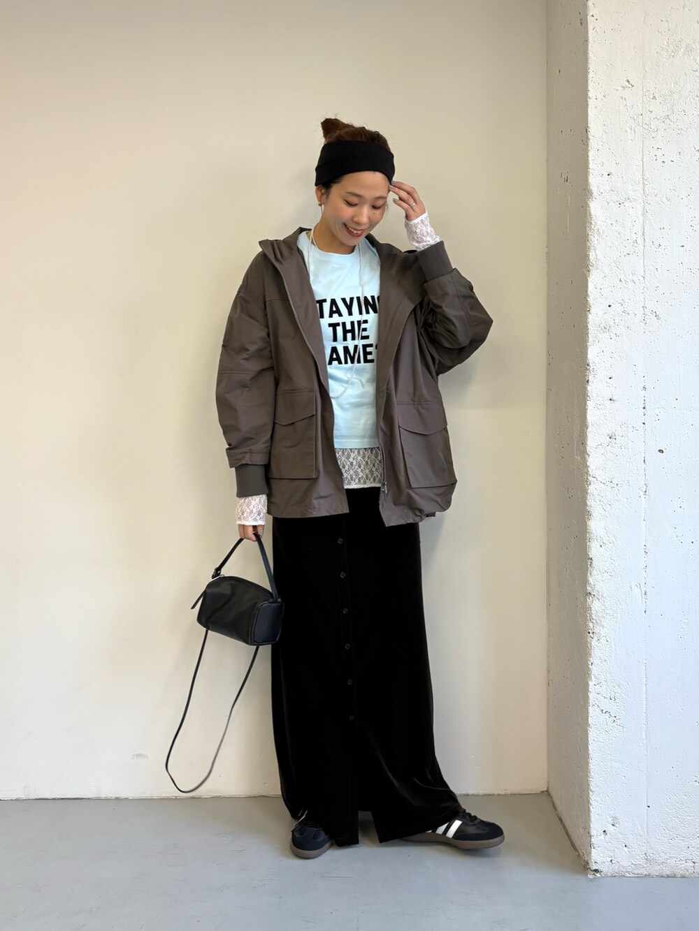 ブルー系のTシャツ/カットソー、グレー系のマウンテンパーカー、ブラック系のスニーカーを着用したレディースの秋コーディネートの2枚目の写真