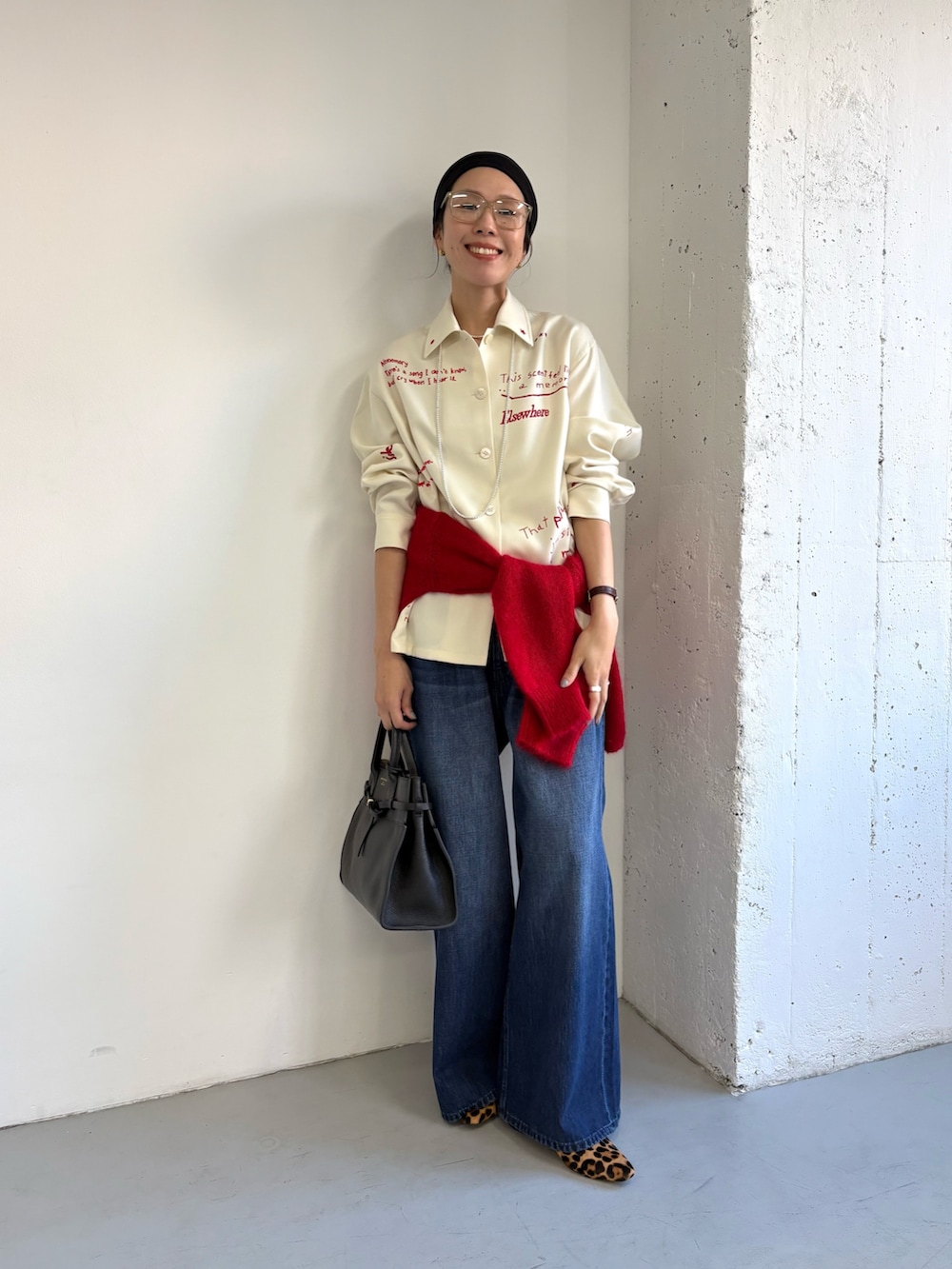 ホワイト系のTシャツ/カットソー、ブラック系のトートバッグ、レッド系のニット/セーターを着用したレディースの秋コーディネートの4枚目の写真