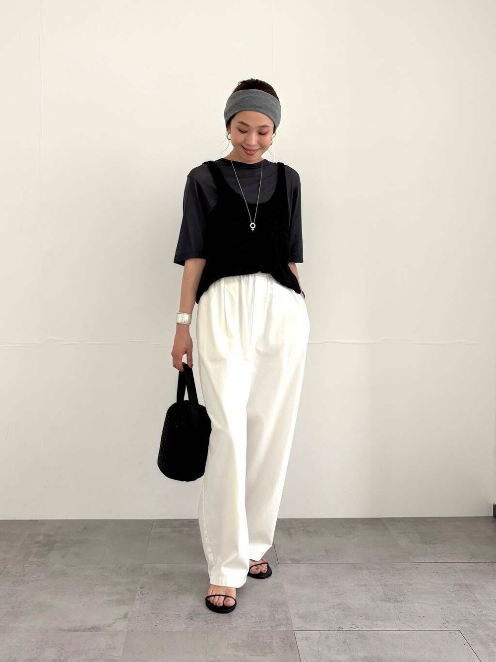 ブラック系のかごバッグ、ホワイト系のその他パンツ、ブラック系のサンダルを着用したレディースの夏コーディネートの6枚目の写真