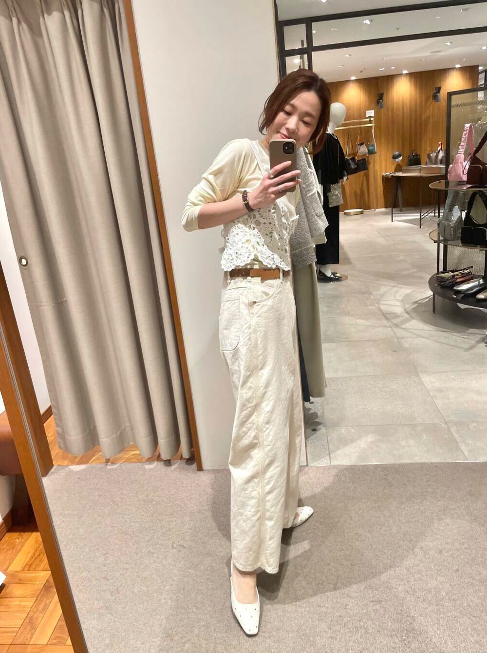 イエロー系のTシャツ/カットソー、グリーン系のトレンチコート、ホワイト系のニット/セーターを着用したレディースの春コーディネートの5枚目の写真