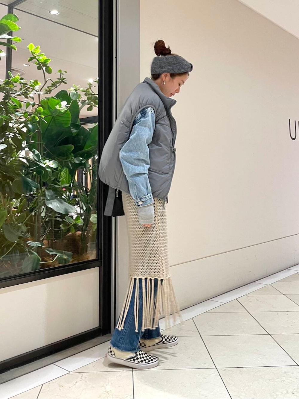 ベージュ系のスカート、ホワイト系のTシャツ/カットソー、グレー系のダウンベストを着用したレディースの冬コーディネートの3枚目の写真