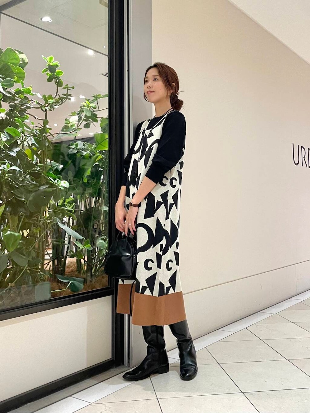 ブラック系のショルダーバッグ、ブラウン系のその他アウター、ホワイト系のニット/セーターを着用したレディースの秋コーディネートの6枚目の写真