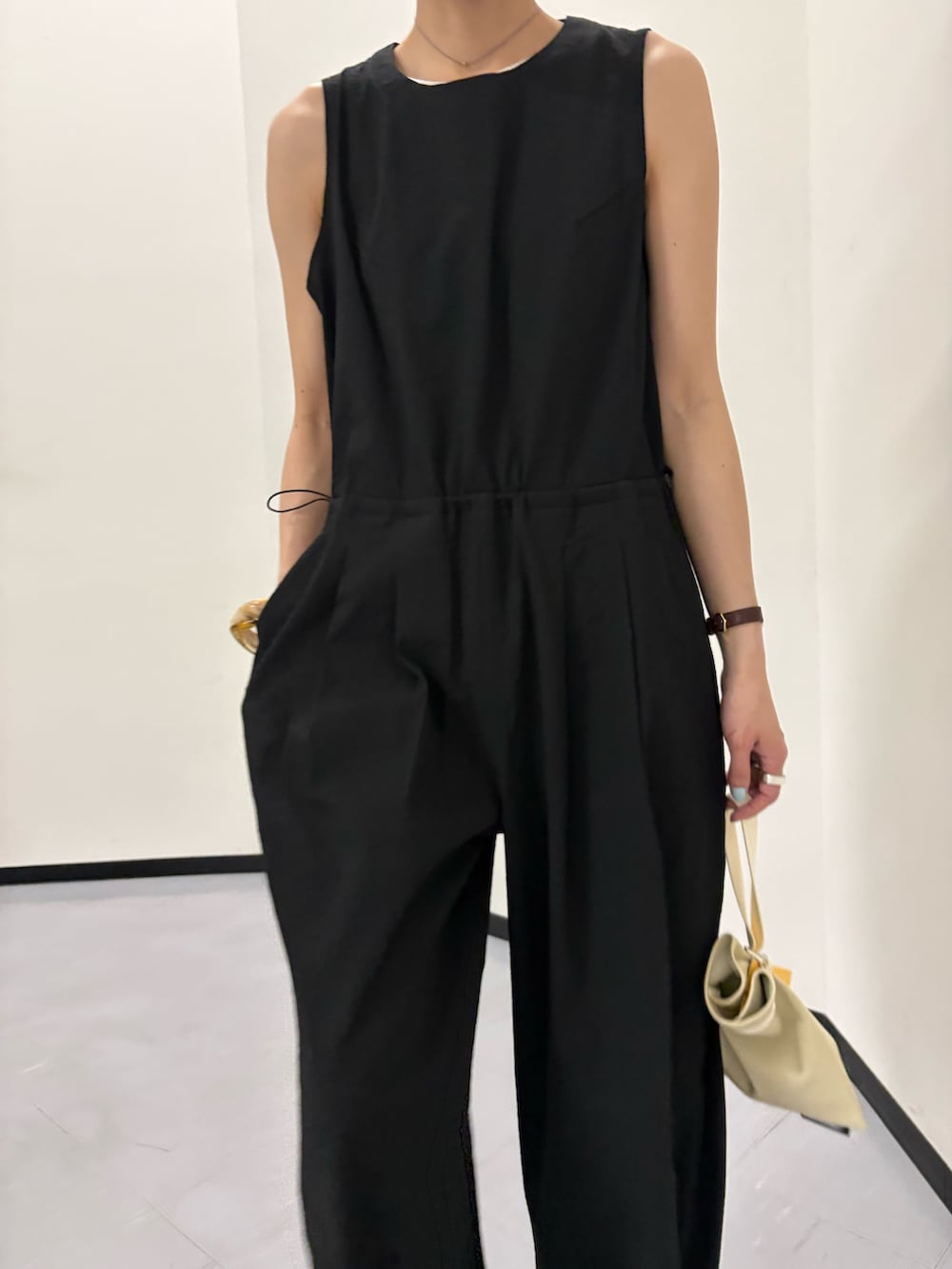 ブラック系のその他パンツ、ホワイト系のハンドバッグ、ブルー系のキャップを着用したレディースの春コーディネートの6枚目の写真