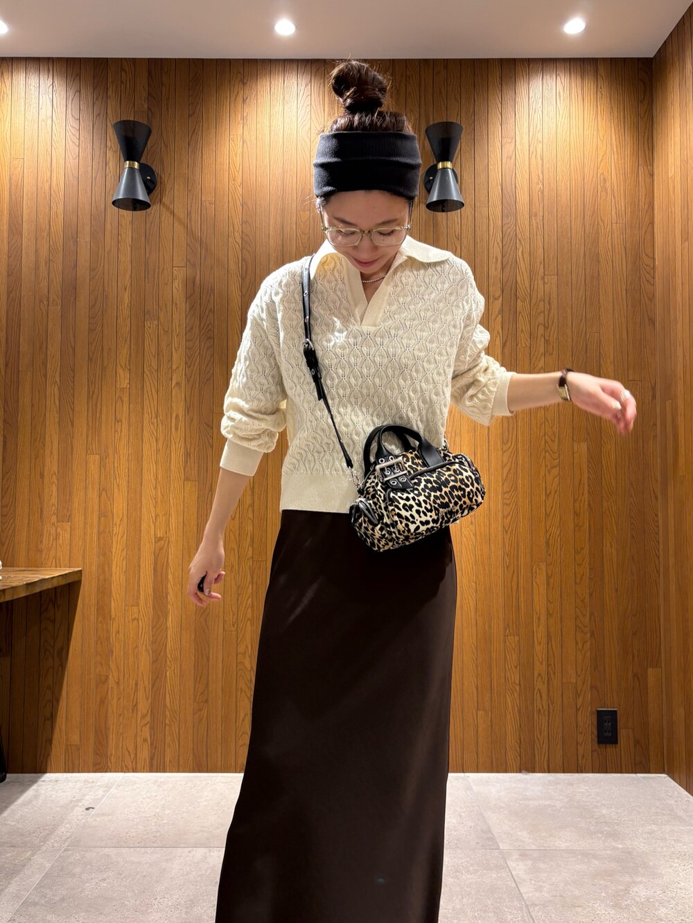 グリーン系のステンカラーコート、ブラウン系のスカート、その他のハンドバッグを着用したレディースの冬コーディネートの6枚目の写真