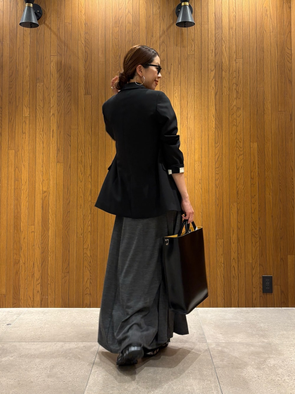 グレー系のワンピース、ブラック系のTシャツ/カットソー、ブラック系のハンドバッグを着用したレディースの冬コーディネートの3枚目の写真