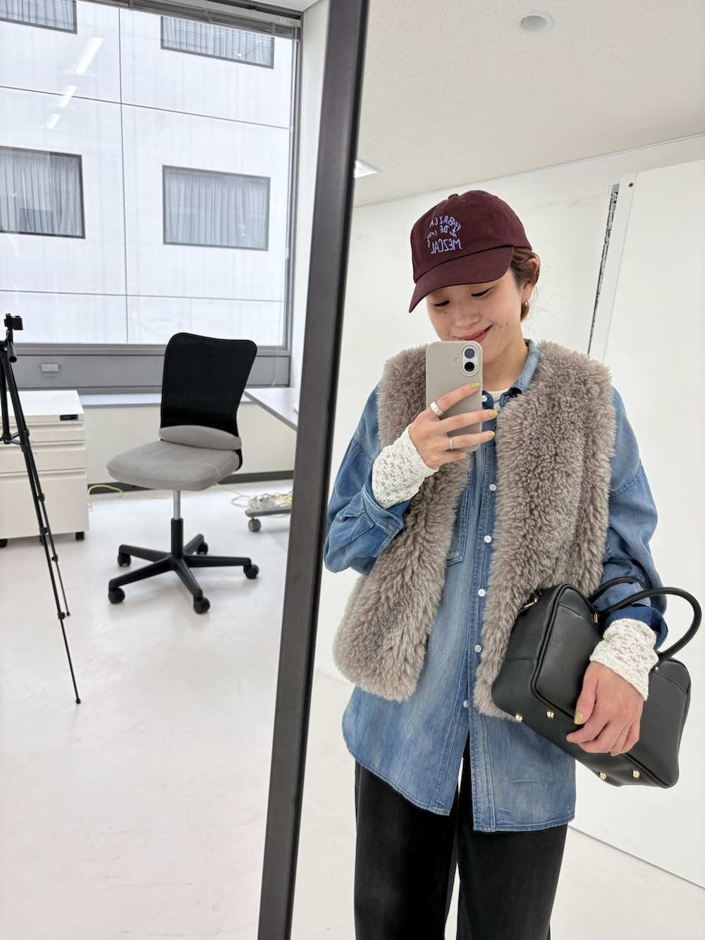 ブルー系のシャツ/ブラウス、グレー系のダウンベスト、ブラック系のデニムパンツを着用したレディースの夏コーディネートの7枚目の写真