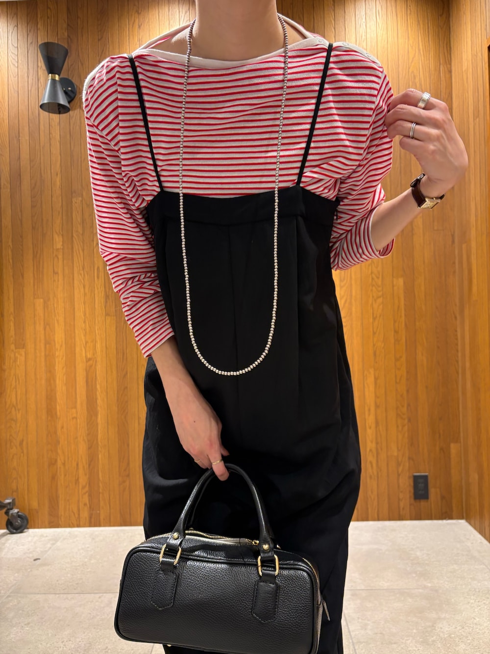 レッド系のTシャツ/カットソー、ブラック系のその他パンツ、ブラック系のハンドバッグを着用したレディースの春コーディネートの5枚目の写真