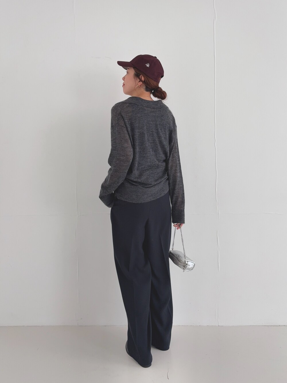 ブラック系のその他パンツ、グレー系のニット/セーター、レッド系のキャップを着用したレディースの夏コーディネートの5枚目の写真