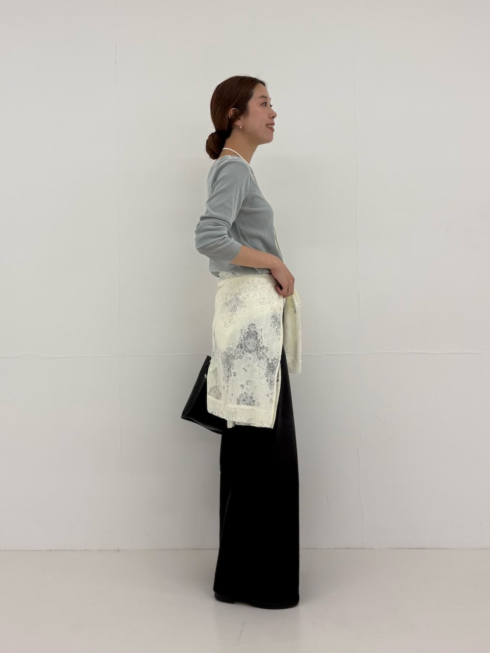 ブラック系のデニムパンツ、ホワイト系のシャツ/ブラウス、ブラック系のショルダーバッグを着用したレディースの夏コーディネートの3枚目の写真
