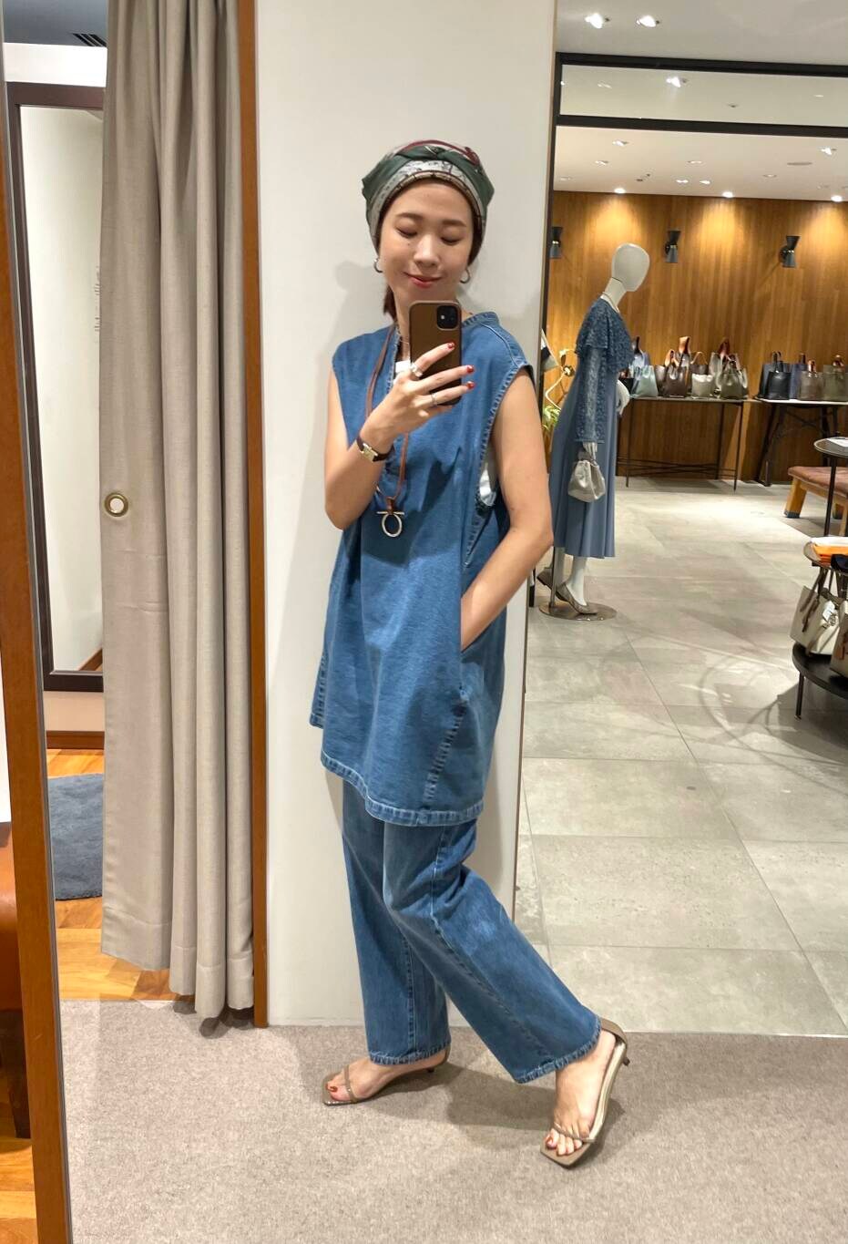 ホワイト系のタンクトップ、ブルー系のベスト、ブルー系のデニムパンツを着用したレディースの夏コーディネートの2枚目の写真