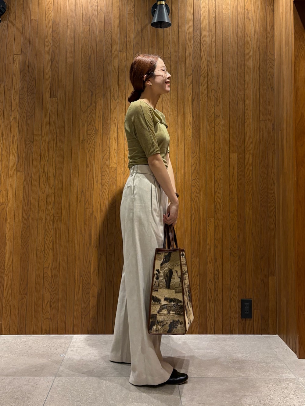 ホワイト系のその他パンツ、グリーン系のTシャツ/カットソー、ベージュ系のハンドバッグを着用したレディースの春コーディネートの4枚目の写真