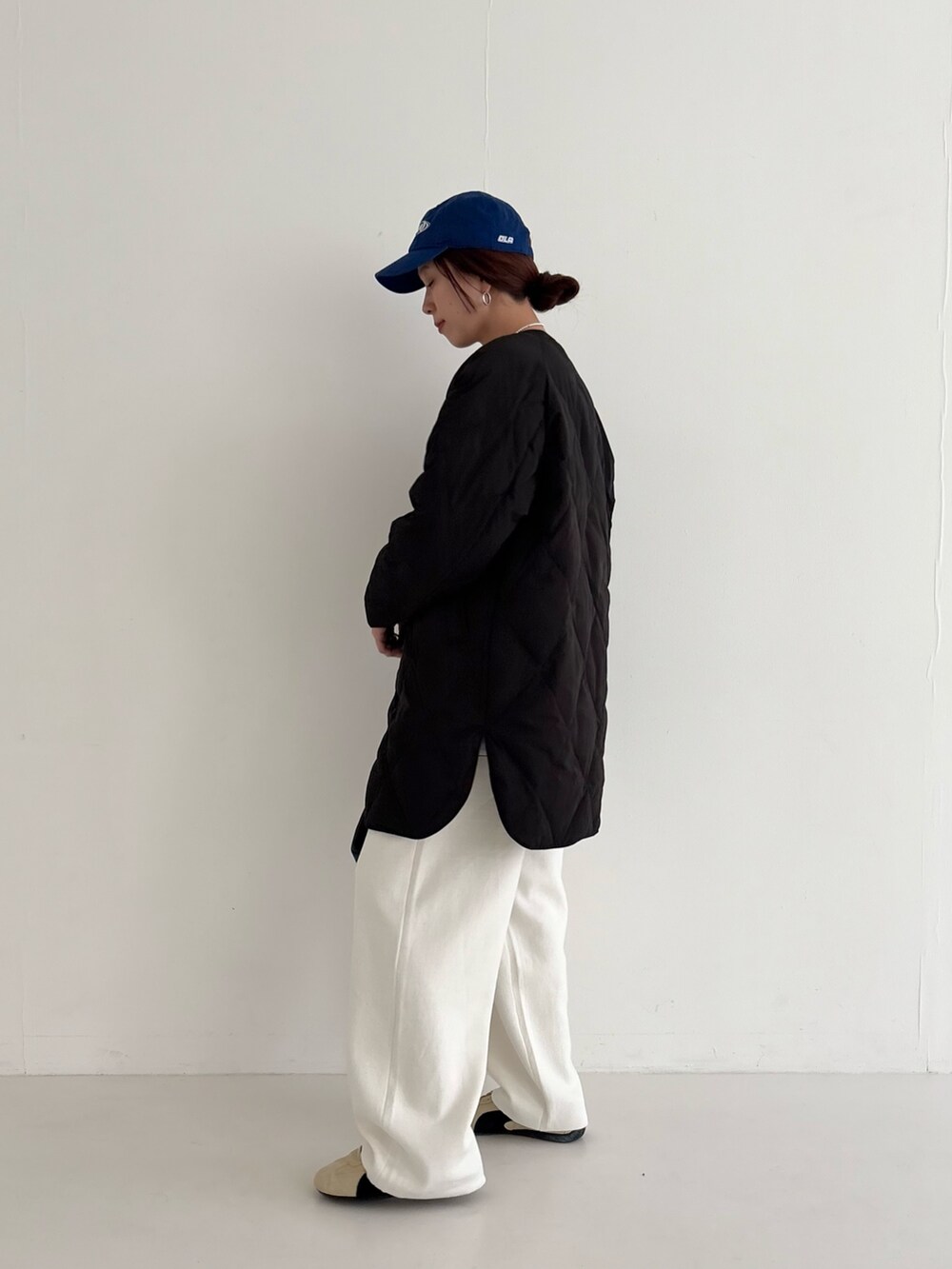 ベージュ系のスニーカー、ブラック系のダウンジャケット/コート、ピンク系のニット/セーターを着用したレディースの秋コーディネートの5枚目の写真