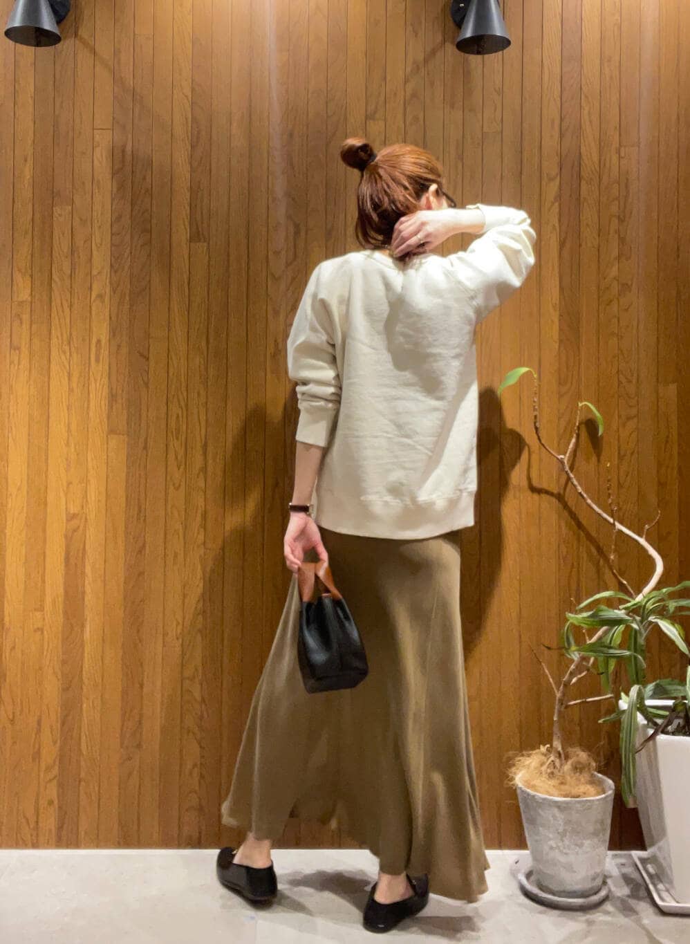 イエロー系のスカート、ベージュ系のスウェットを着用したレディースの冬コーディネートの3枚目の写真