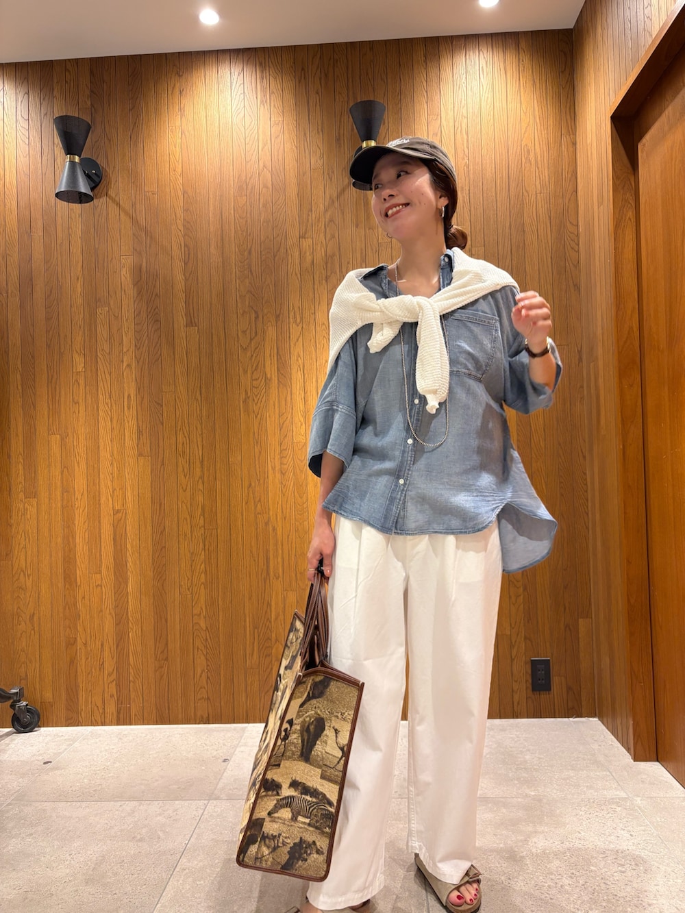 ブルー系のシャツ/ブラウス、ホワイト系のその他パンツ、ベージュ系のハンドバッグを着用したレディースの春コーディネートの7枚目の写真