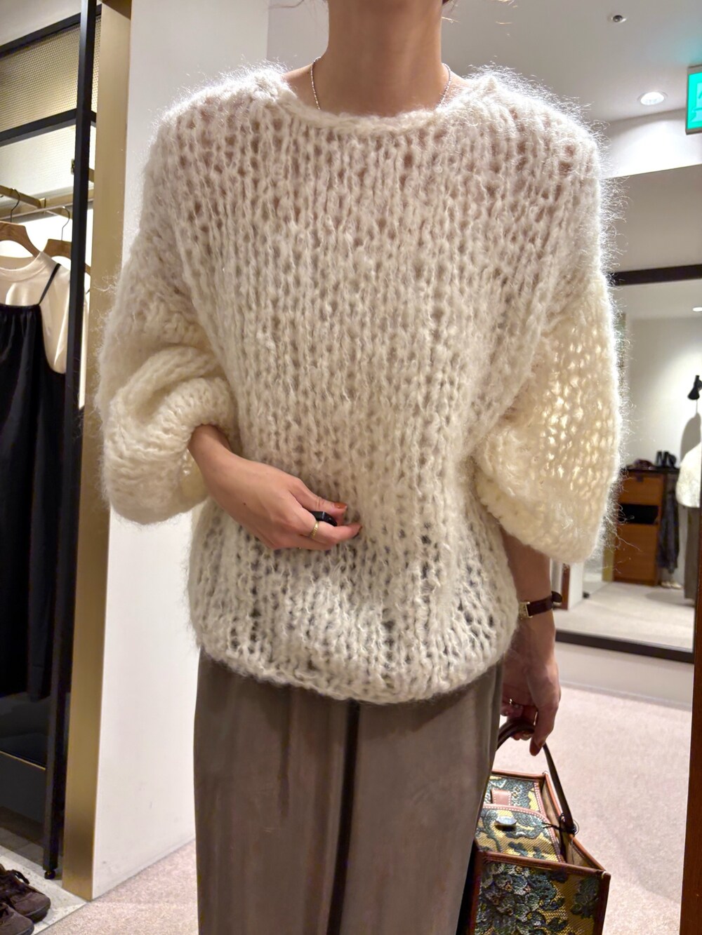 ホワイト系のニット/セーター、ブラック系のローファー、グリーン系のスカートを着用したレディースの秋コーディネートの6枚目の写真