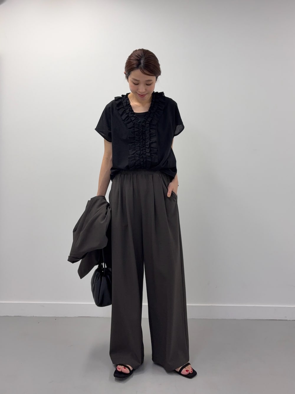 ブラック系のシャツ/ブラウス、ブラック系のショルダーバッグ、ブラック系のサンダルを着用したレディースの春コーディネートの5枚目の写真