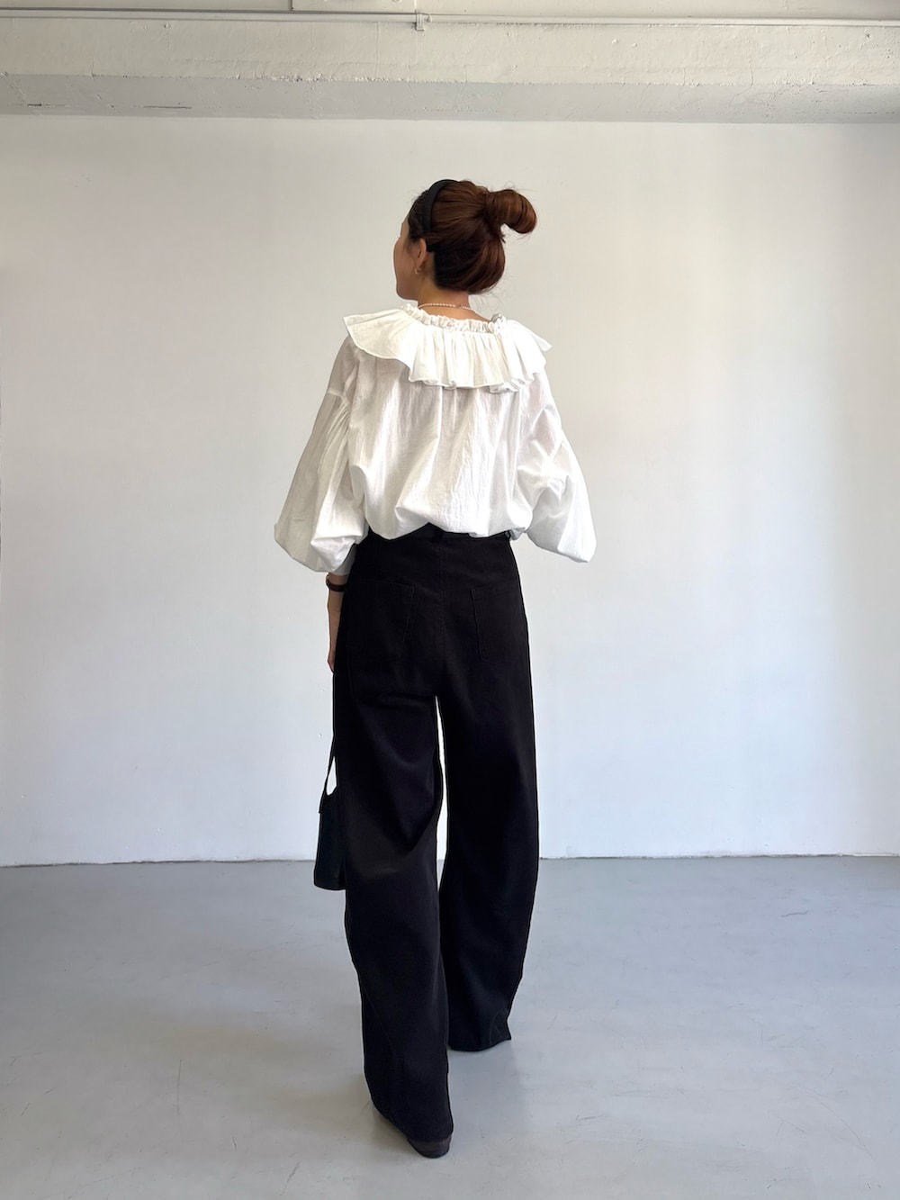 グレー系のその他パンツ、ホワイト系のシャツ/ブラウス、ブラック系のハンドバッグを着用したレディースの秋コーディネートの4枚目の写真