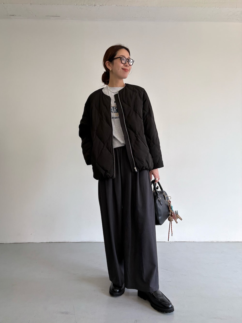 ブラック系のダウンジャケット/コート、グレー系のその他パンツ、ブラック系のローファーを着用したレディースの冬コーディネートの7枚目の写真