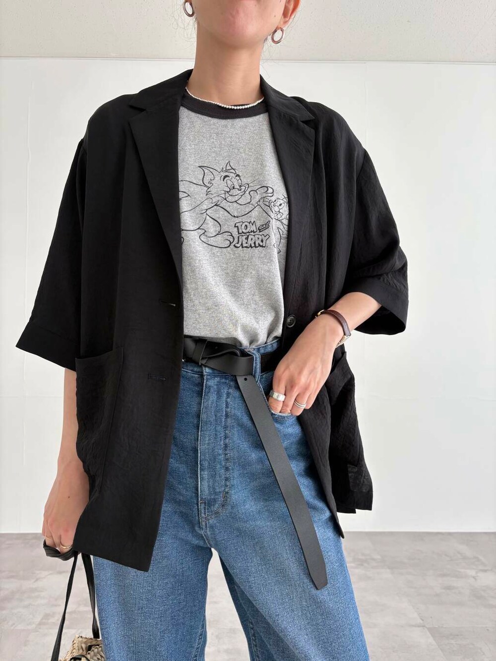 グレー系のTシャツ/カットソー、ブルー系のデニムパンツ、ブラック系のサンダルを着用したレディースの春コーディネートの5枚目の写真
