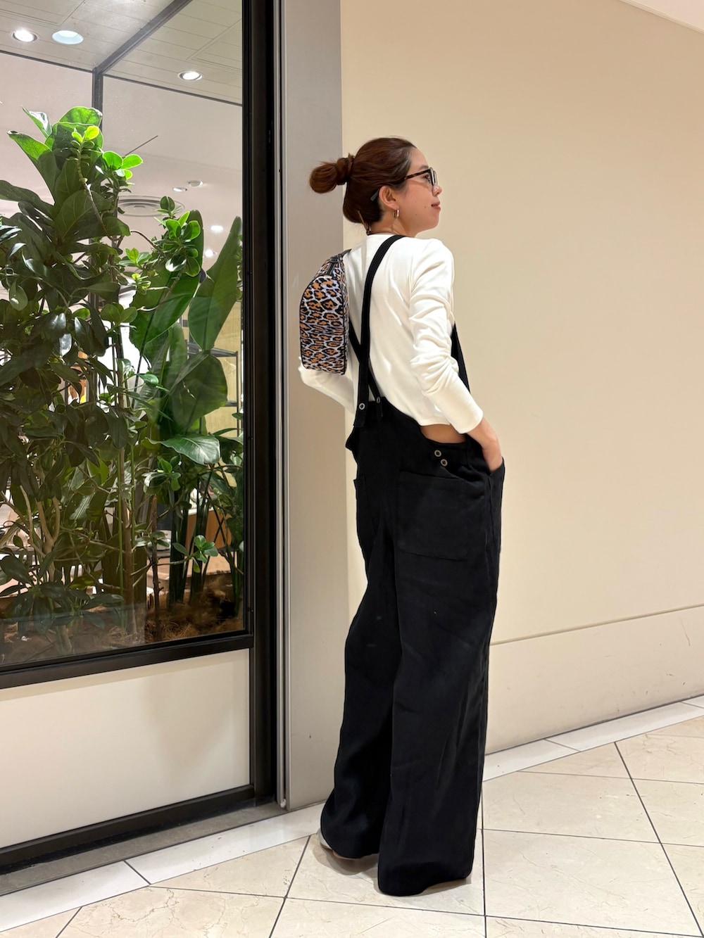 ブラック系のサロペット/オーバーオール、ホワイト系のTシャツ/カットソー、パープル系のハンドバッグを着用したレディースの春コーディネートの3枚目の写真