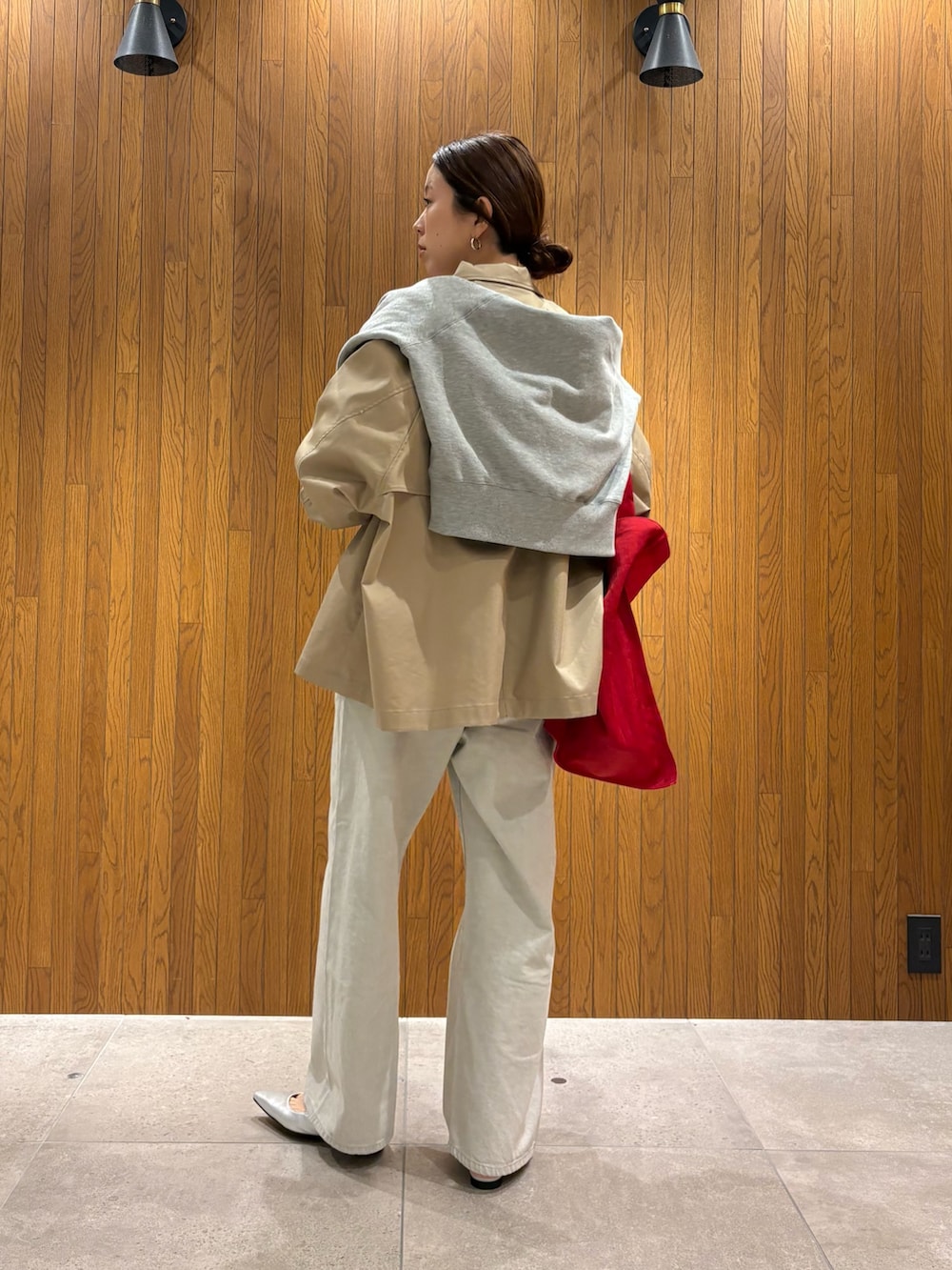 ベージュ系のトレンチコート、グレー系のデニムパンツ、シルバー系のパンプスを着用したレディースの冬コーディネートの4枚目の写真