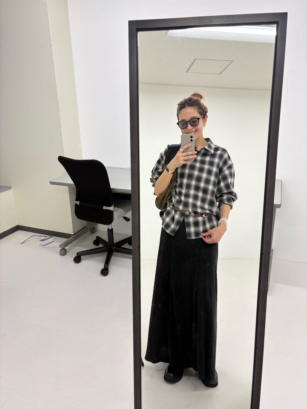 ブラック系のスカート、ブラウン系のショルダーバッグ、ブラック系のシャツ/ブラウスを着用したレディースの秋コーディネートの8枚目の写真