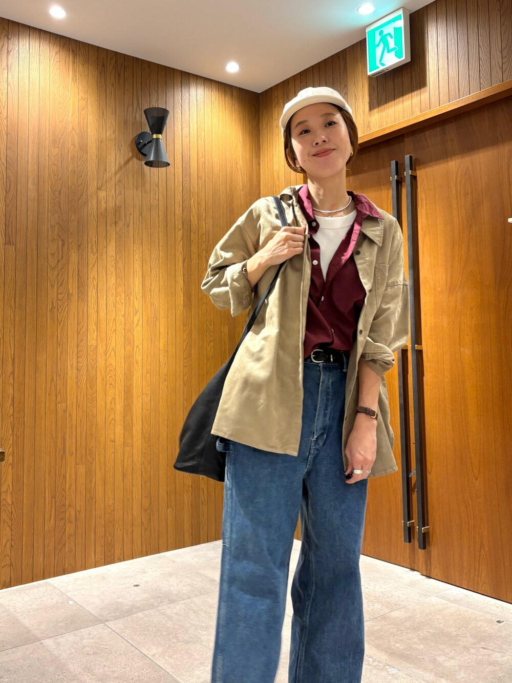 ブルー系のデニムパンツ、レッド系のシャツ/ブラウス、ブラック系のローファーを着用したレディースの夏コーディネートの6枚目の写真