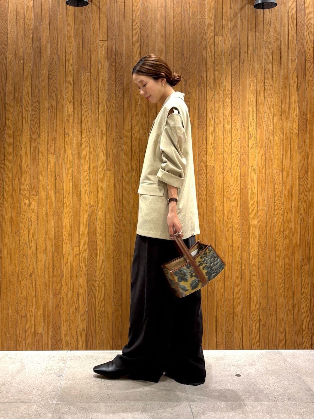 ホワイト系のその他アウター、ブラウン系のその他パンツ、ベージュ系のハンドバッグを着用したレディースの秋コーディネートの7枚目の写真