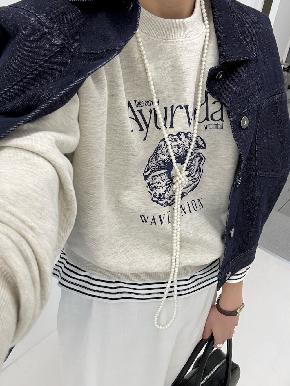 ブルー系のデニムジャケット、ベージュ系のスウェット、ブラック系のブーツを着用したレディースの冬コーディネートの7枚目の写真