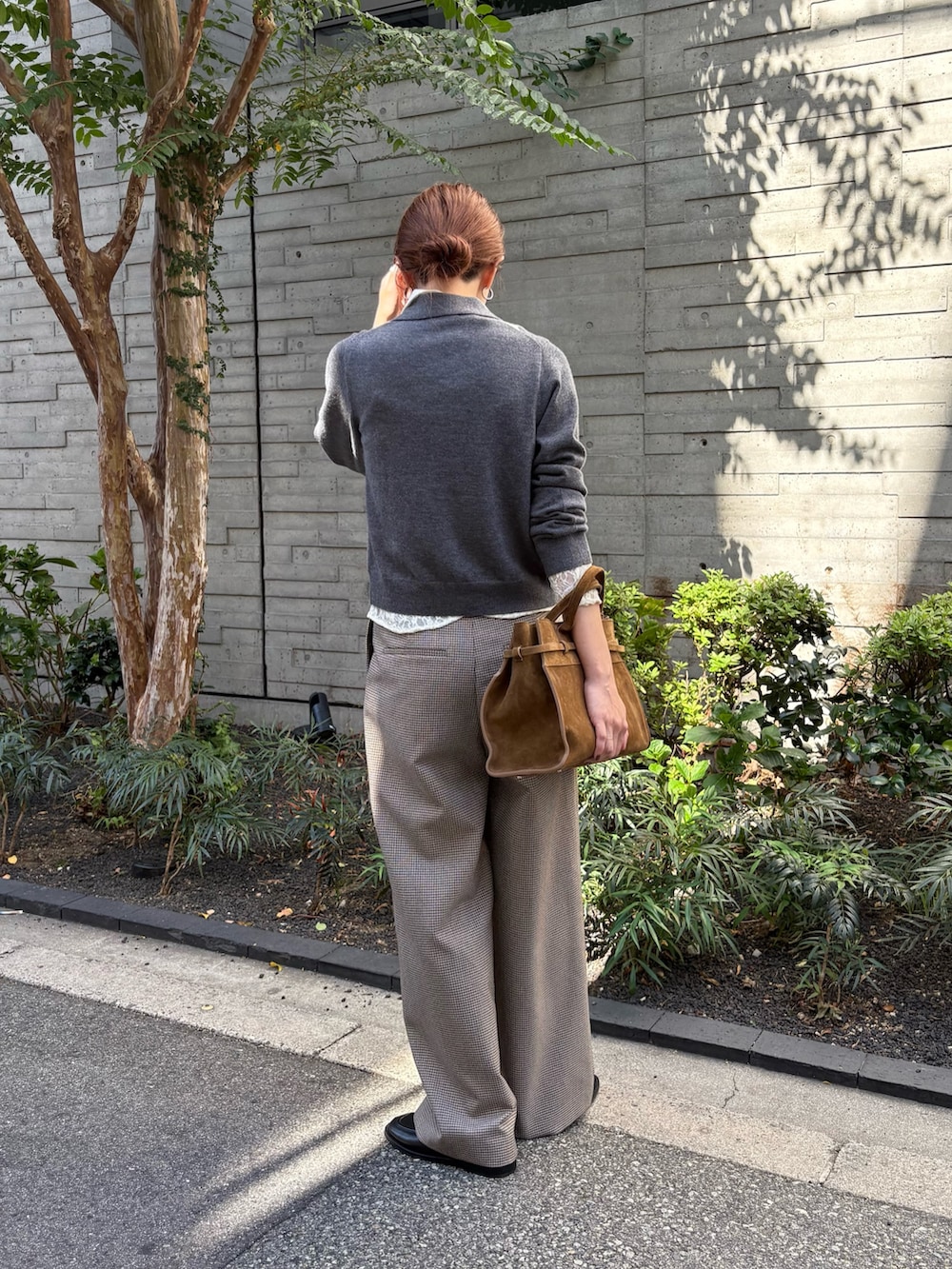 グレー系のニット/セーター、ホワイト系のシャツ/ブラウス、グレー系のその他パンツを着用したレディースの秋コーディネートの4枚目の写真