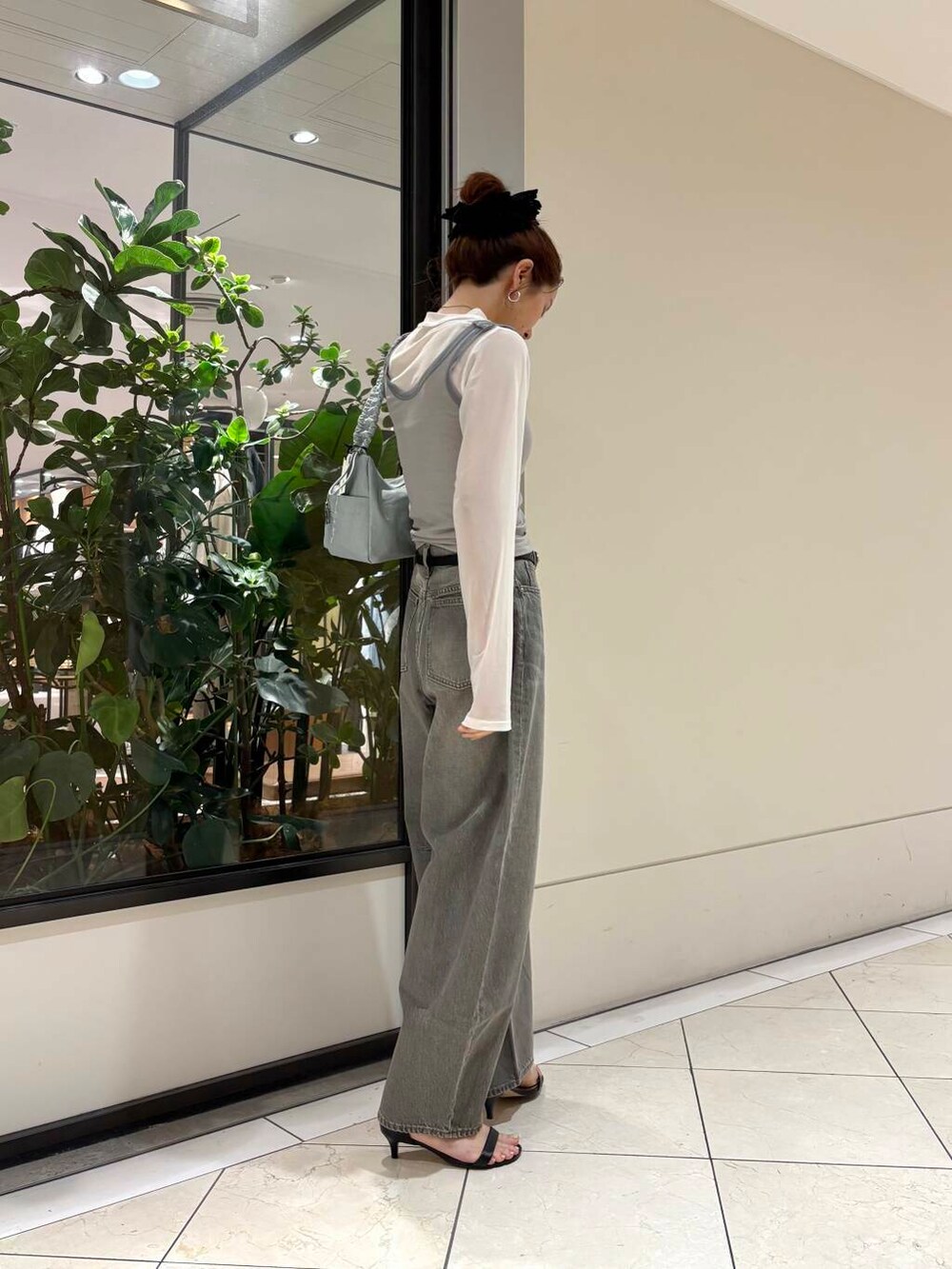 グリーン系のデニムパンツ、グリーン系のショルダーバッグ、グレー系のTシャツ/カットソーを着用したレディースの夏コーディネートの6枚目の写真