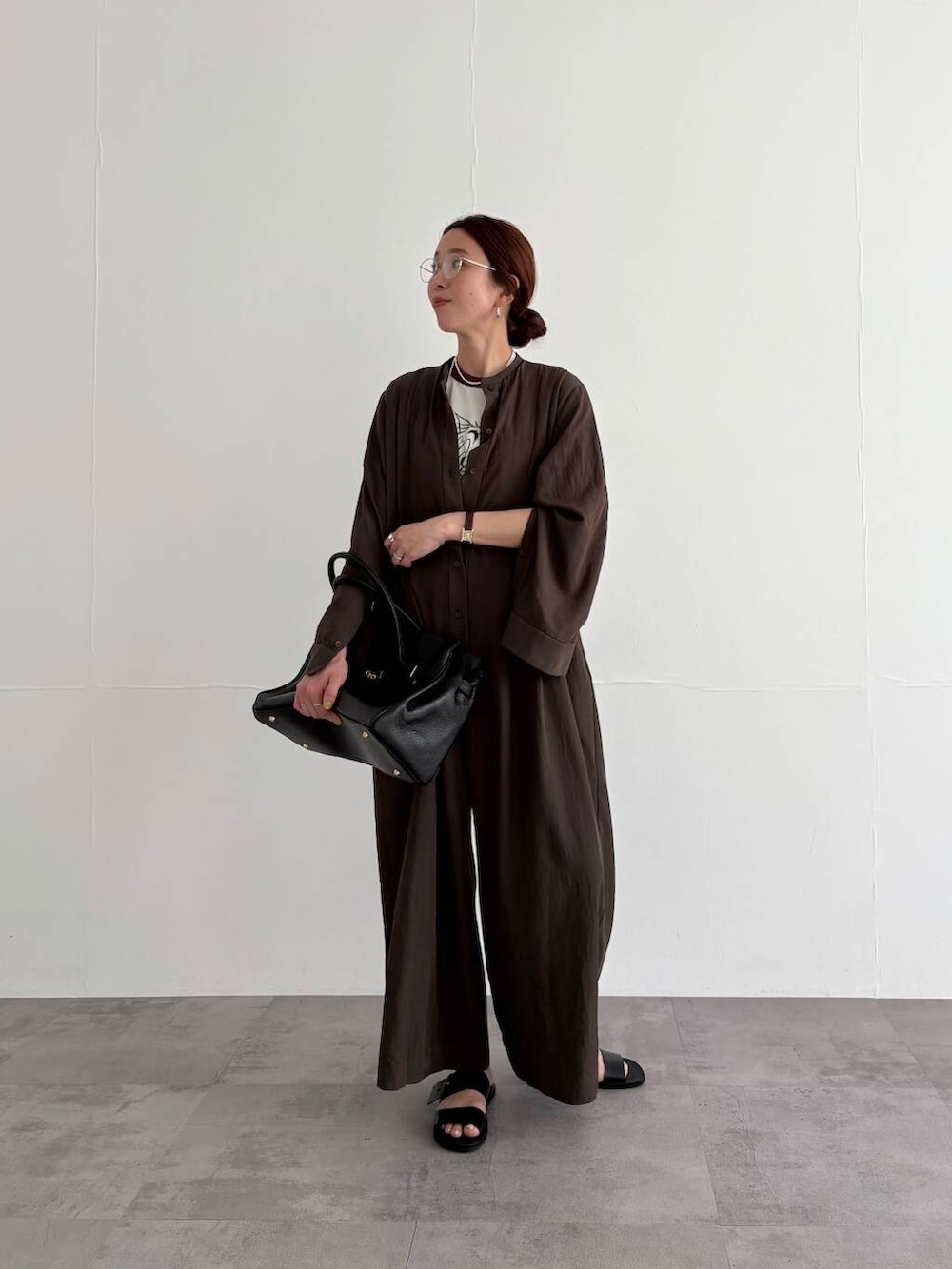 ブラウン系のサロペット/オーバーオール、ホワイト系のTシャツ/カットソー、ブラック系のサンダルを着用したレディースの春コーディネートの5枚目の写真