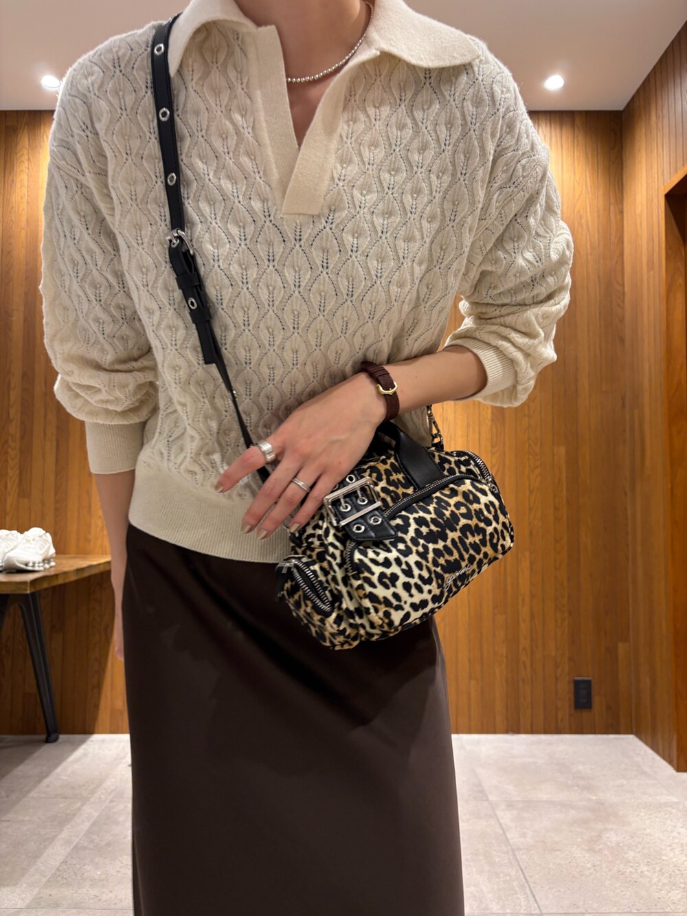 グリーン系のステンカラーコート、ブラウン系のスカート、その他のハンドバッグを着用したレディースの冬コーディネートの7枚目の写真