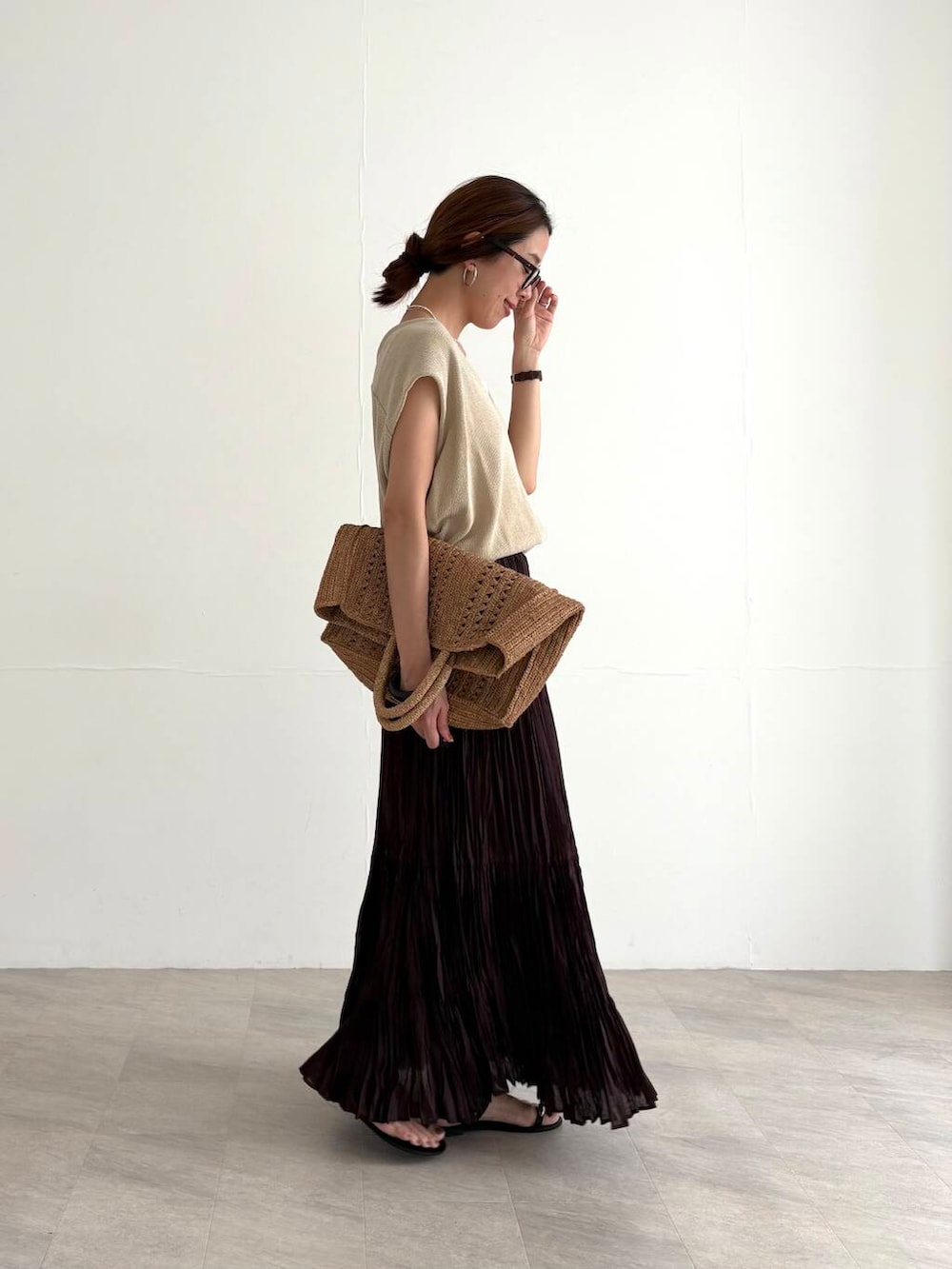 ホワイト系のキャミソール、ブラウン系のスカート、ベージュ系のベストを着用したレディースの夏コーディネートの5枚目の写真